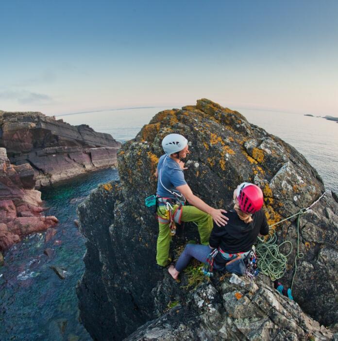 Two people rock climbing on the cliff