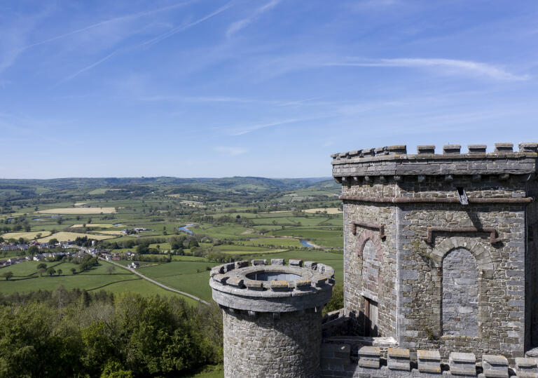 A castle tower overlooking a green valley.