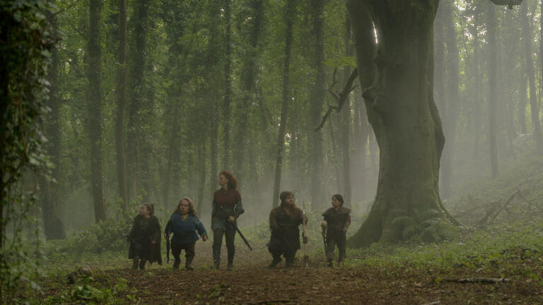 Von links nach rechts: Mims (Annabelle Davis), Willow Ufgood (Warwick Davis), Jade (Erin Kellyman), Karthy (Simeon Dyer) und Nelwyn Villager (Arti Shah) in einem mystischen Wald im Lucasfilm Willow.