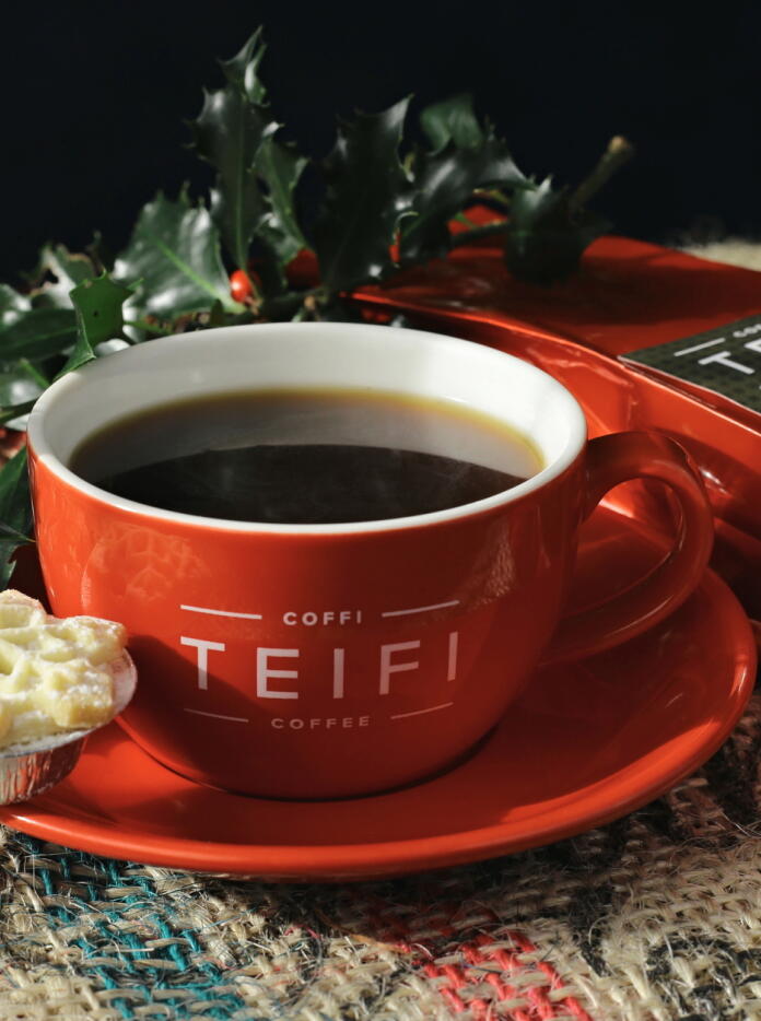 coffee cup and saucer, with the words Coffi TEIFI on the cup and packet of coffee plus holly and minced pie.