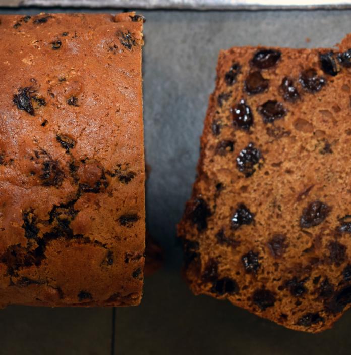 A fruit loaf with a slice cut off.