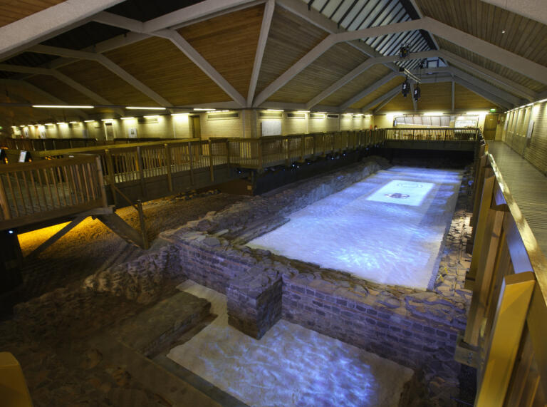 indoor pool with lights and stone walls 