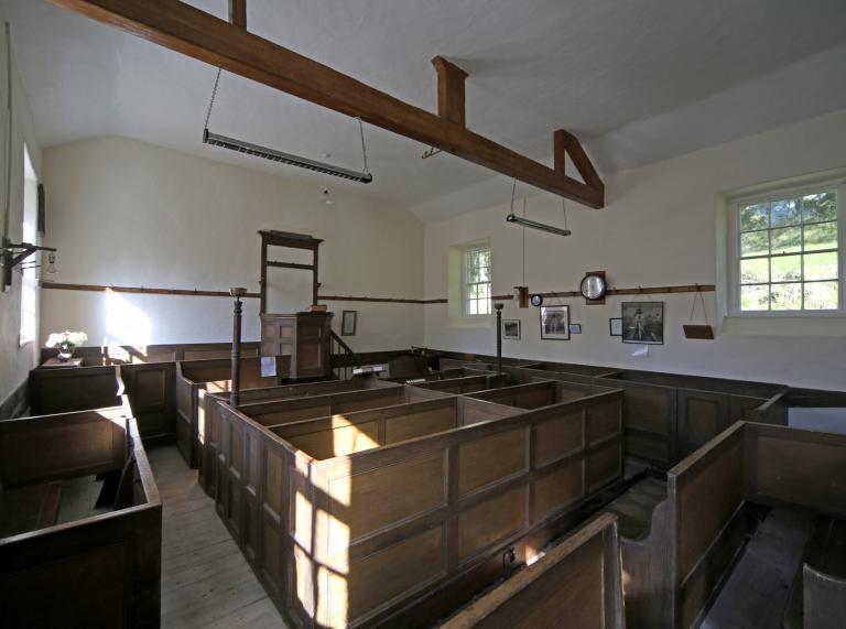 interior of church with white walls and wooden furniture.