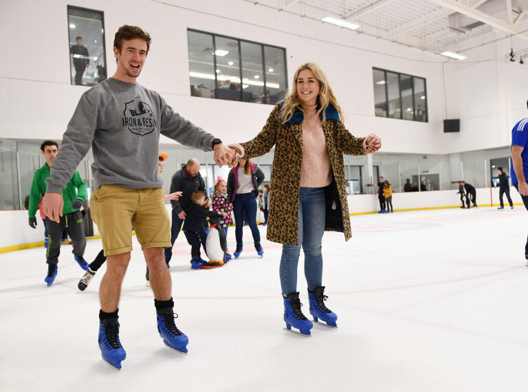 Two people skating across the ice.