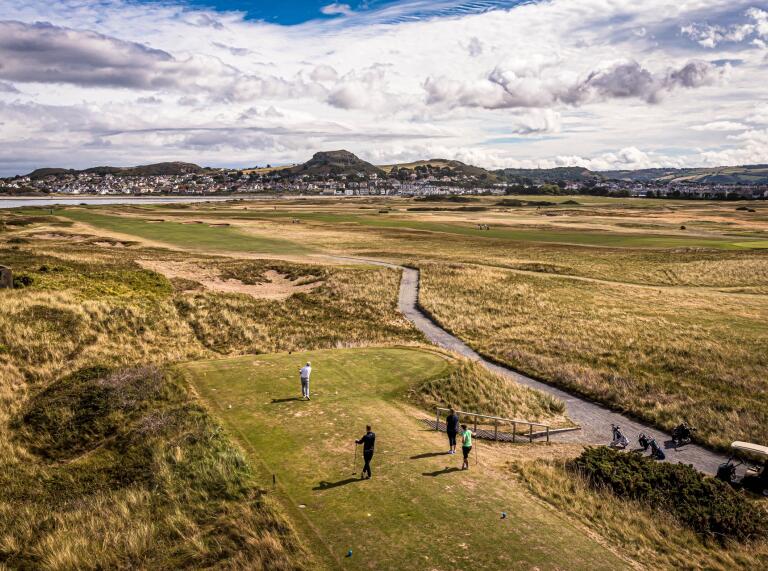 People playing golf at a coastal golf course.