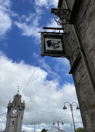 A pub sign and a church tower.