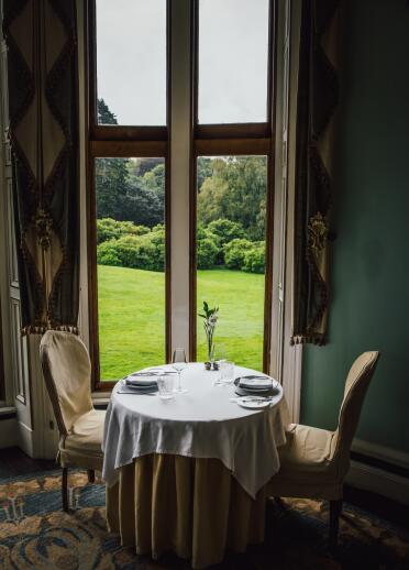 A table for two in a beautifully decorated restaurant, overlooking gardens. 