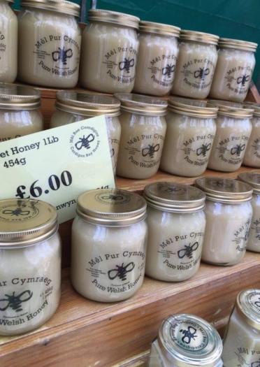 stacked jars of honey for sale with price sign