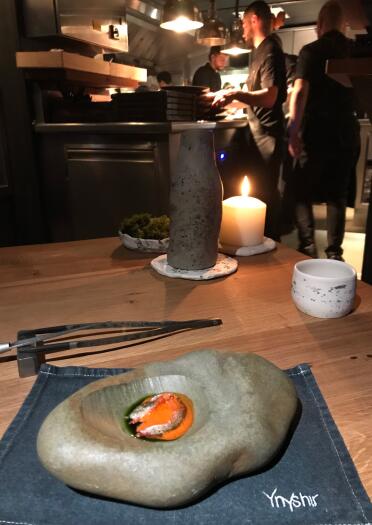A hollowed out stone with prawn and wild garlic inside.