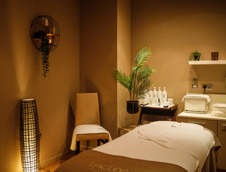 A spa treatment room with a massage bed and calming decor.