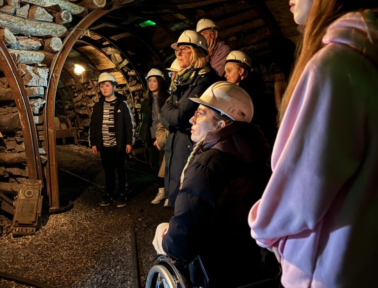 people in coal mine, including woman in wheelchair.