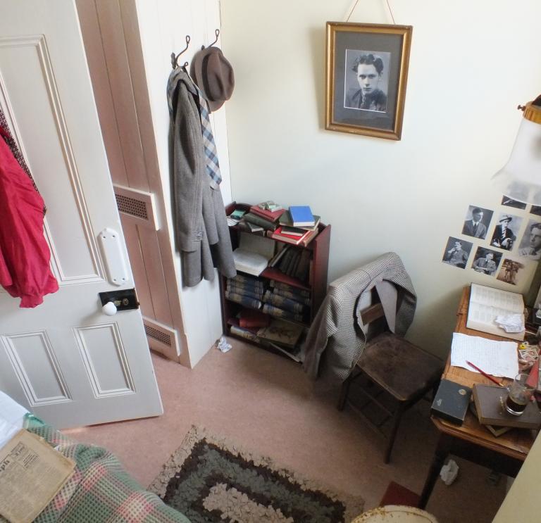 interior of a bedroom with a written desk and photo, shot from above.
