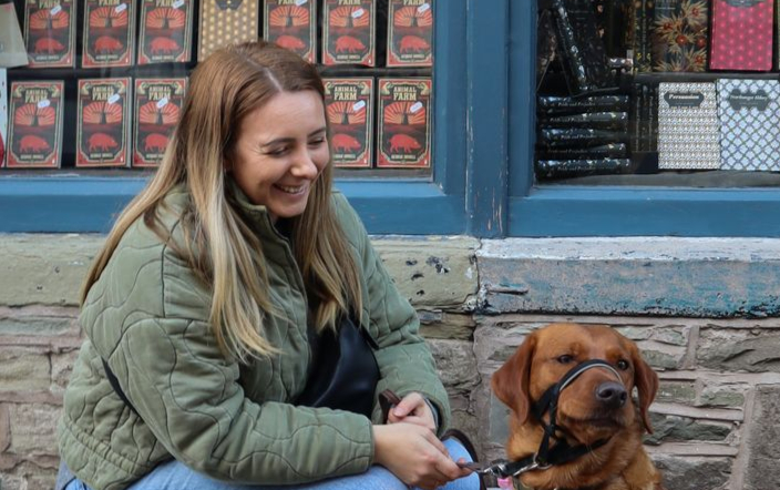 woman and dog outside bookshop.