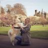 A big, white furry dog and her owner in a park.