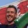 Ash Dykes holding a Welsh flag above his head (cropped).