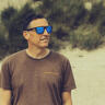 A man wearing sunglasses stood on a beach.