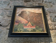 A tapestry of a black bull on a stone wall.