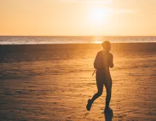 silhouette of runner on beach with sunset.