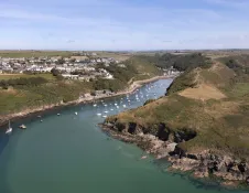aerial view of picturesque coastal village, with harbour and boats.