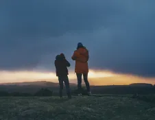 Two people watching a sunset from high up.