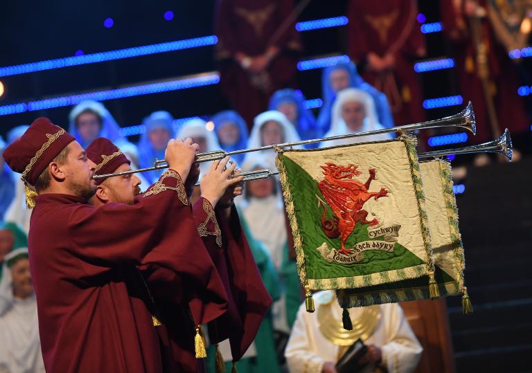 Ceremonial musicians with Welsh flags on instruments.
