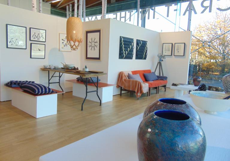 Image of the inside of a gallery with pottery, furniture and textiles on show