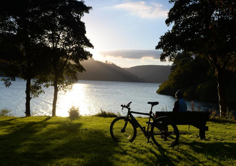 Bike parked up in front of lake.