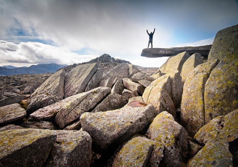 Walker on Cantilever Rock with hands in the air, Snowdonia