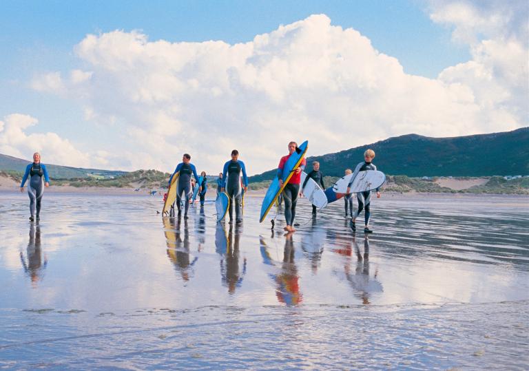 Group heading into the water on a surfing lesson