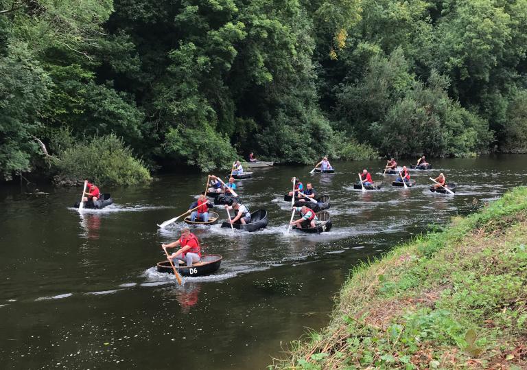 A group of people racing in coracles in West Wales