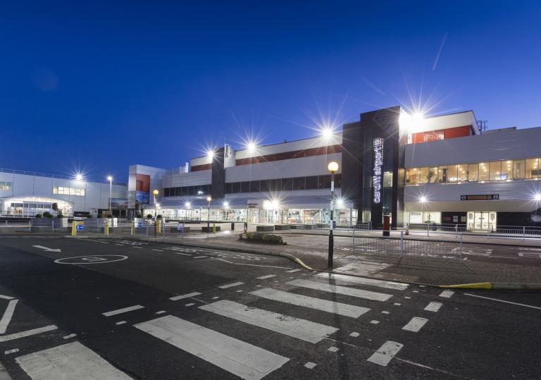 External shot of Cardiff Airport brightly lit at night.