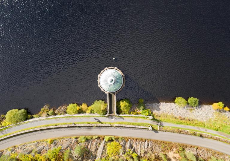 Aerial shot of road by reservoir 