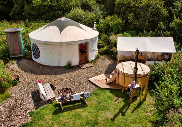 A yurt from above with a hot tub and outside seating.