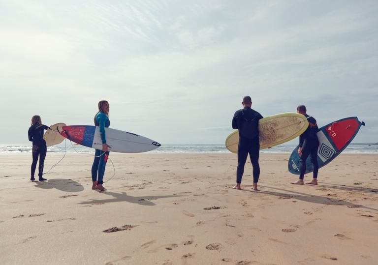four surfers on beach.