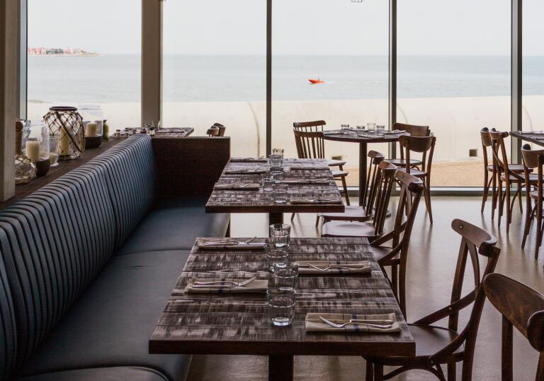 Interior of a restaurant, with view of sea.