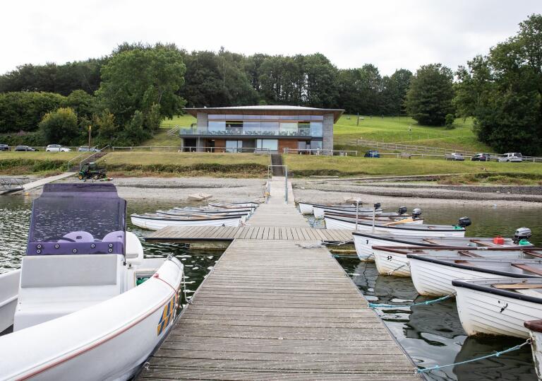 boats and jetty, with visitor centre in background.