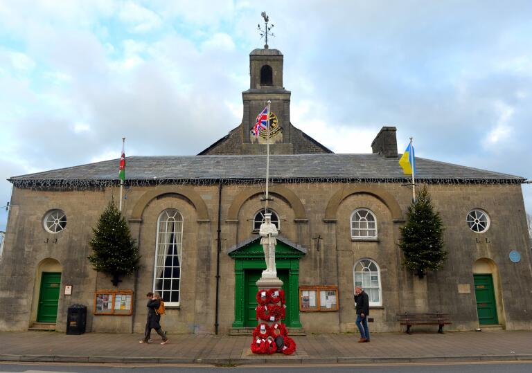 town hall with statue and Christmas trees.