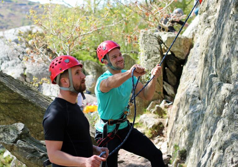 instructor showing man how to use ropes.
