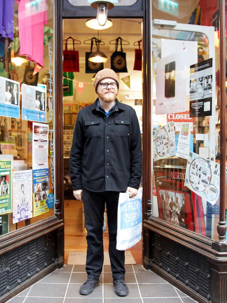 A man standing in the door way of a record shop