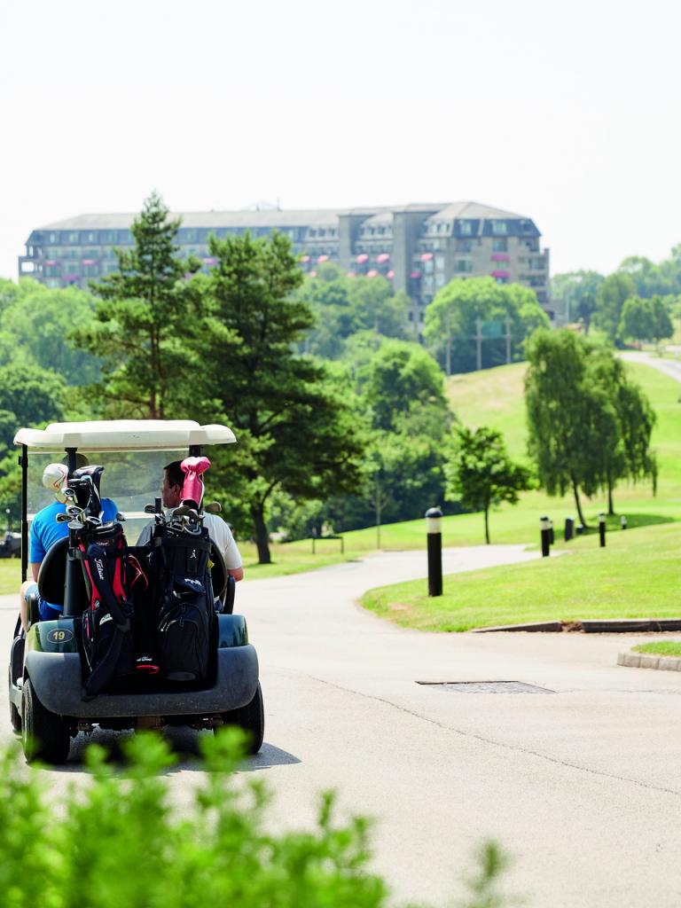Golf cart on Celtic Manor Resort golf resort with the hotel in the background.