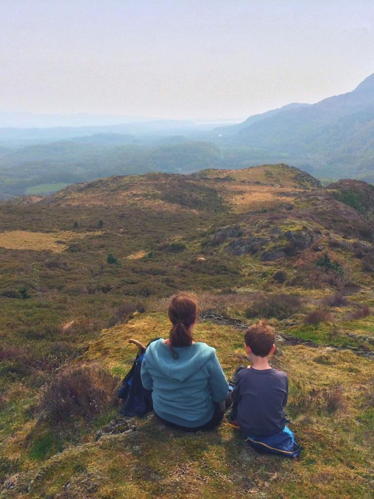 Woman and boy sat looking at views across the countryside.