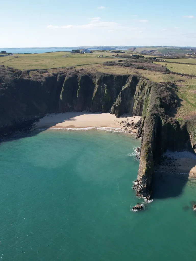 Small sandy coves in between high rugged cliffs. 