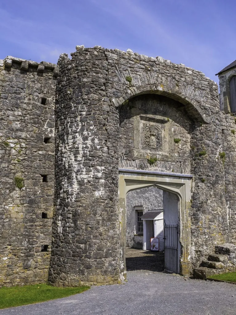 A partially ruined castle gate and round tower.