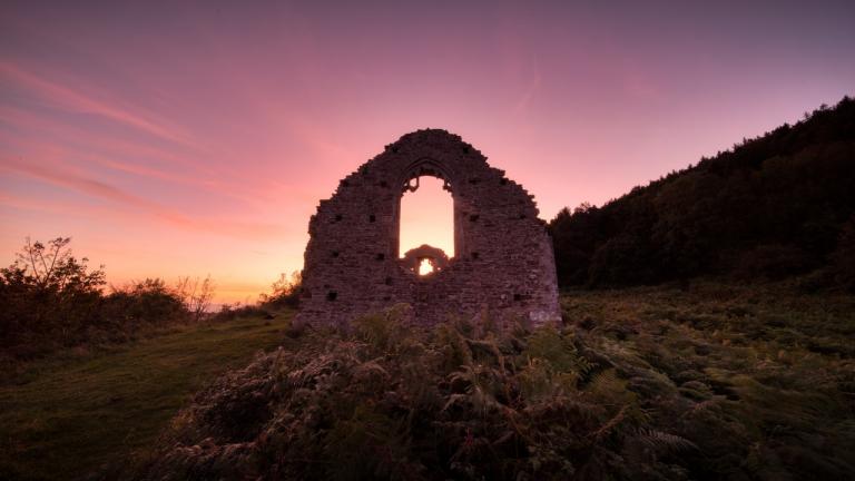 Dusk sunshine behind the ruins of an old chapel