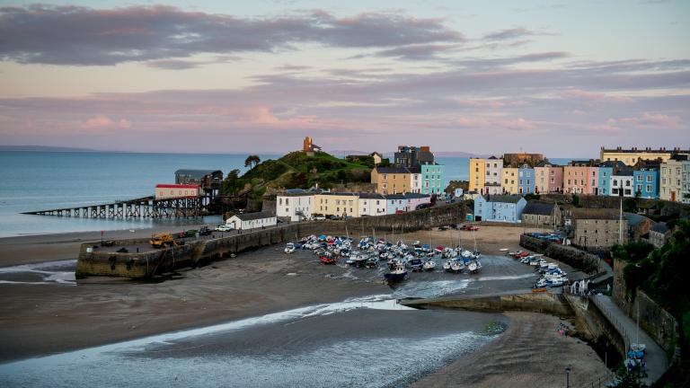 Image of Tenby Harbour beach, colourful houses and the lifeboat station.