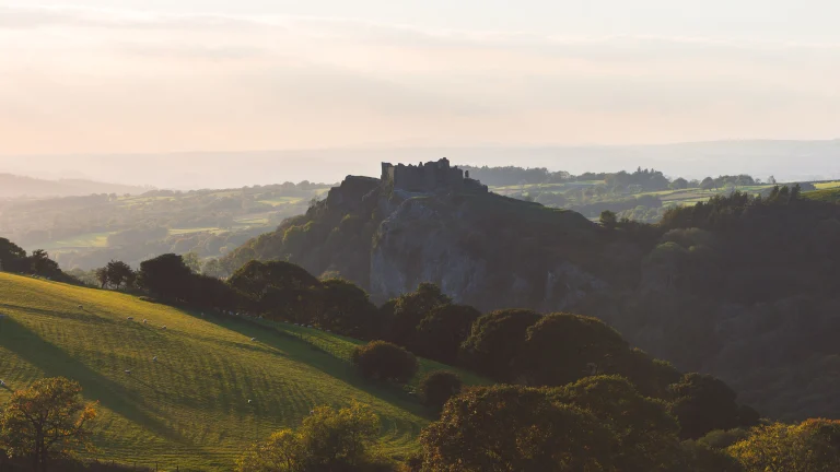 Schloss auf einem Hügel mit umliegender Landschaft.