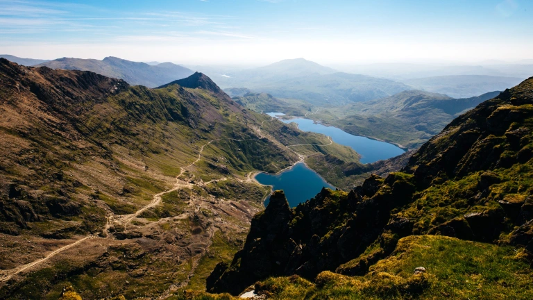 Foto aufgenommen an einem hellen Tag mit Blick von Snowdon auf Berge und Seen.