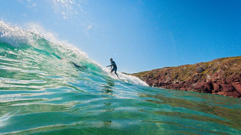 Surfer in water on wave, Westdale Bay, Pembrokeshire. Image taken in the water