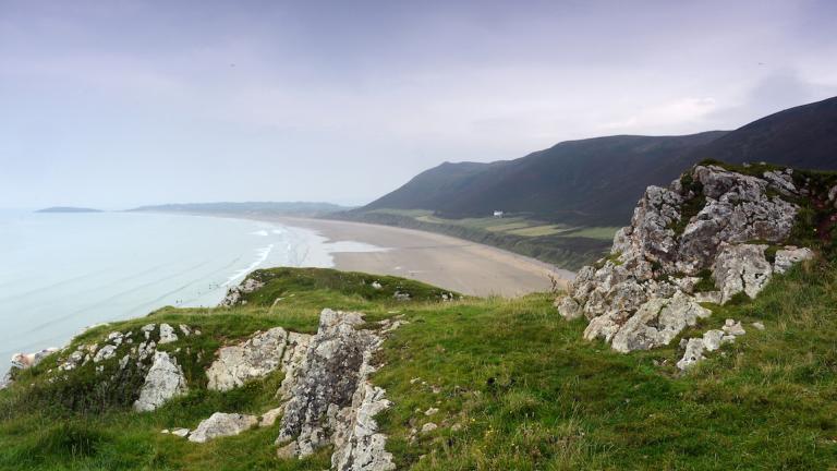 A view from the grassy cliff tops overlooking Rhossili beach.