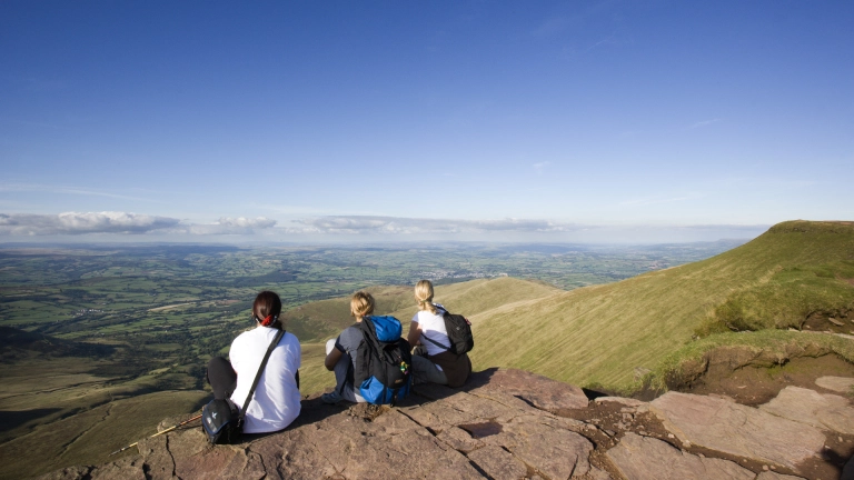 Walkers sat down overlooking mountains.